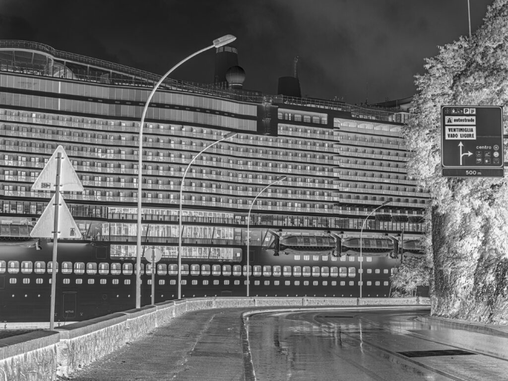 A large cruise ship leaving Savona's harbour is seen from the state roadn°1 "Aurelia". For years, these ships have been causing environmental damages to marine fauna and to the foundations of old houses in Venice with movement of volumes of water basin with their passage. They are mainly responsible for overtoursim from which several cities suffering, not only in Italy. In 2022 finally, Venice municipality prohibited the passage of cruise ships in the Giudecca Canal due to the environmental risk they pose. Savona June 2023. Italy